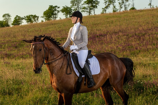 Comment tenir les rênes lors de l'équitation ? Jeune femme cavalière avec son cheval