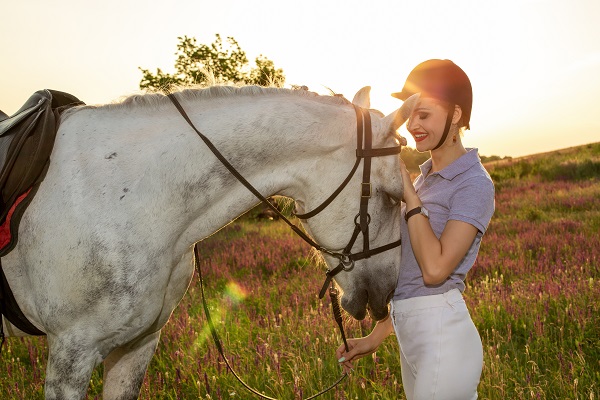 Inconvénients de l'équitation pour les femmes, Jeune fille jockey caressant et embrassant un cheval 