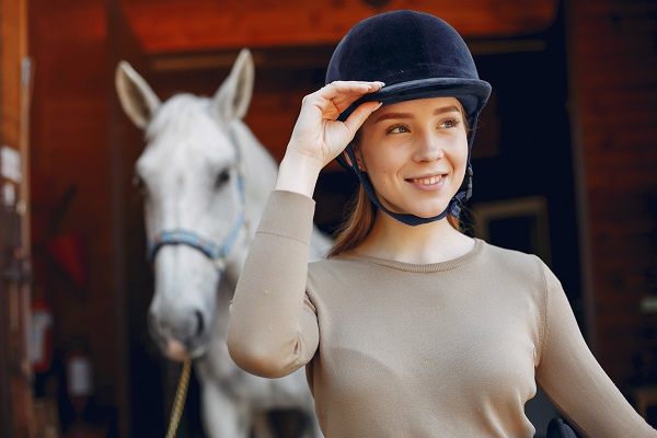 belle-femme-debout-avec-cheval-Comment entretenir son casque d'équitation?