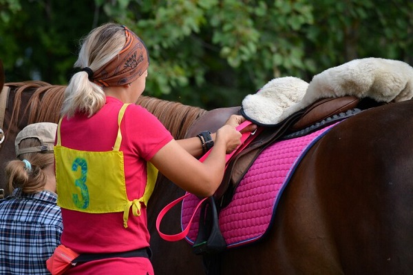 belle-fille-prepare-son-cheval-pour-competitioN-Comment choisir un matériel de compétition adapté à sa discipline de prédilection?