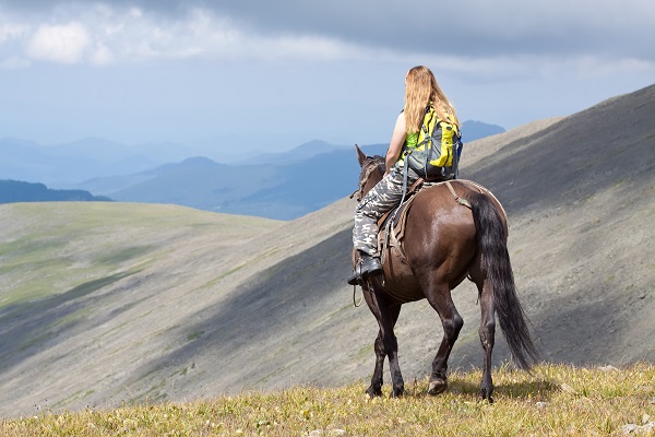 cavalière avec sac a dos -Comment organiser un voyage équestre?