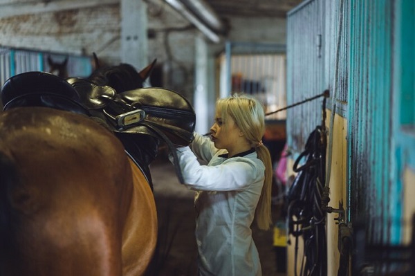 fille prend -coin -cheval-Comment entretenir son matériel d'entraînement en équitation?